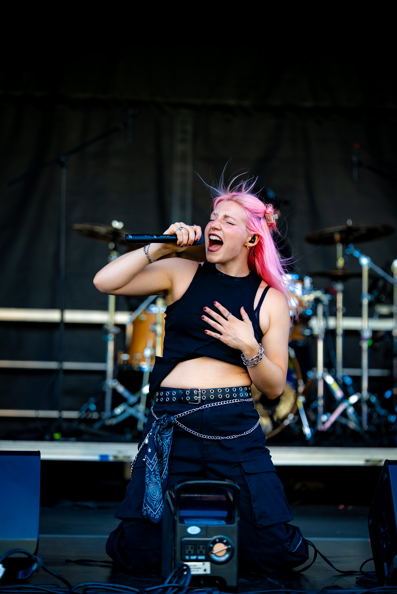 Pink-haired vocalist framed by the outdoor stage