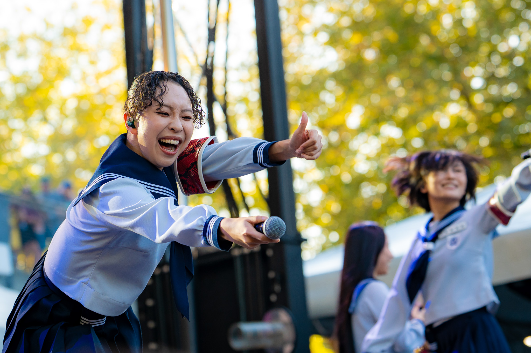 A member of ATARASHII GAKKO! leaning toward the audience