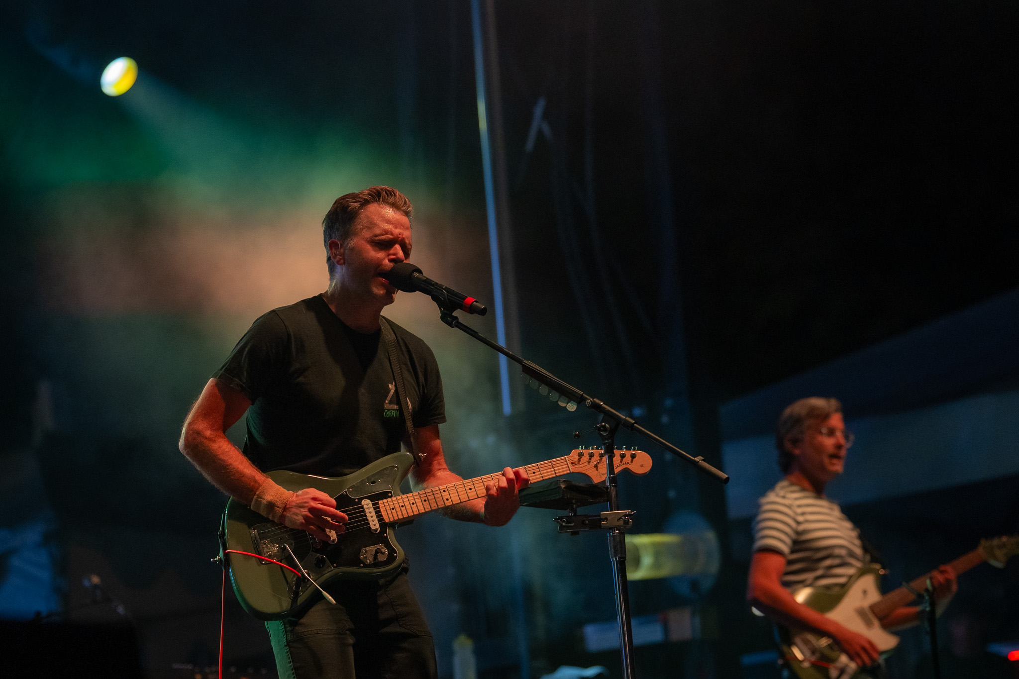 Death Cab for Cutie's bassist performing in deep stage light