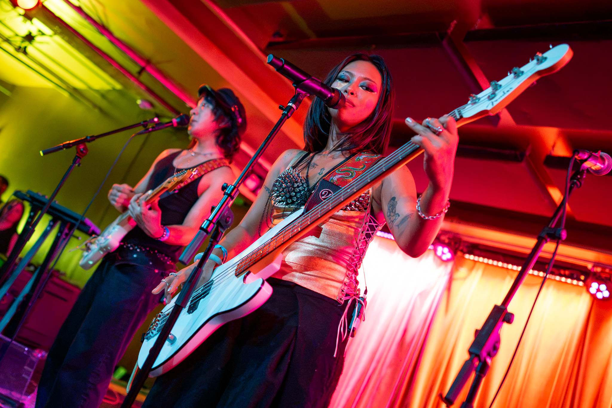 Grace Dumdaw plays bass from a low angle with a bandmate behind her