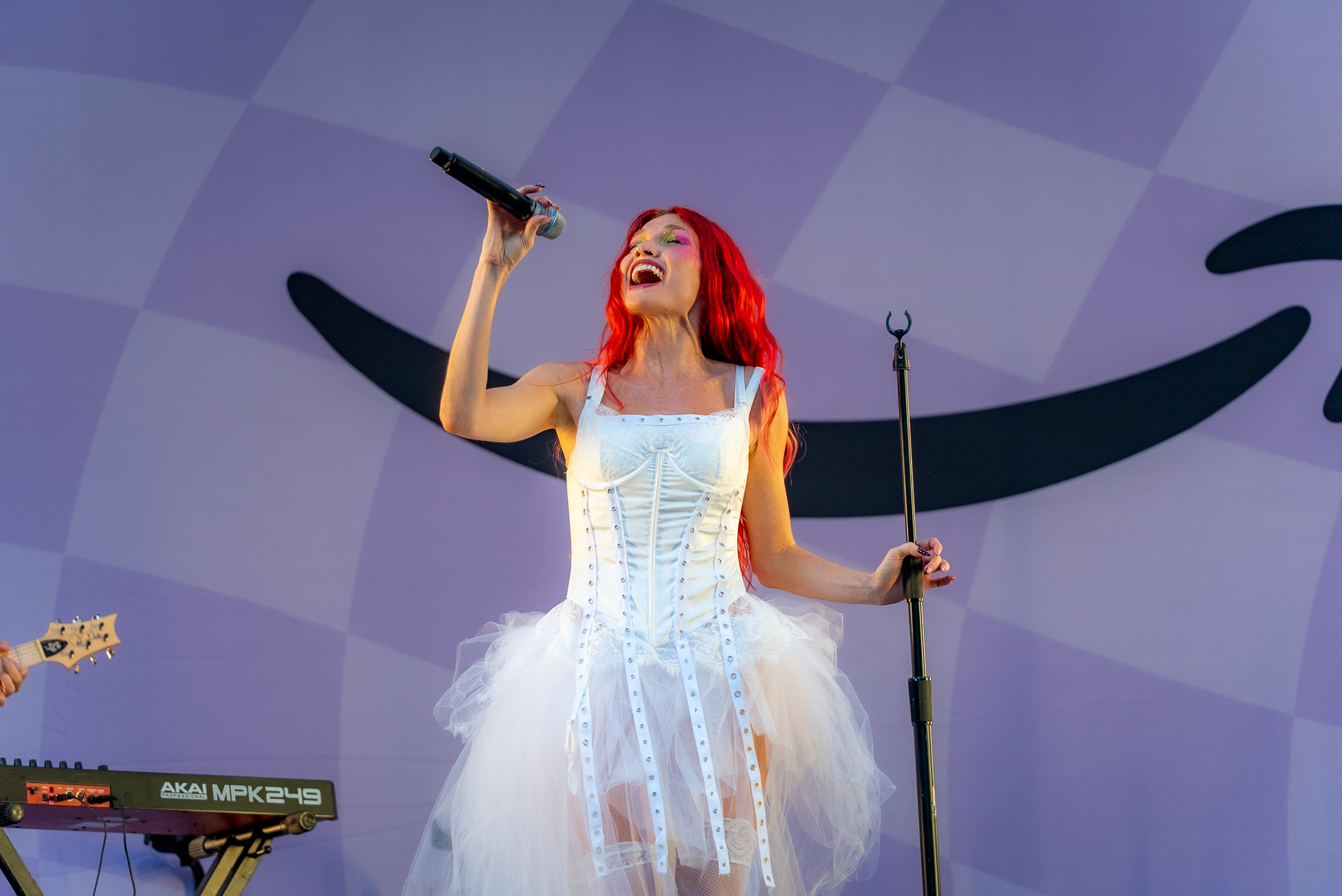 Mandy Lee performing as Cherry Bomb in a white stage look