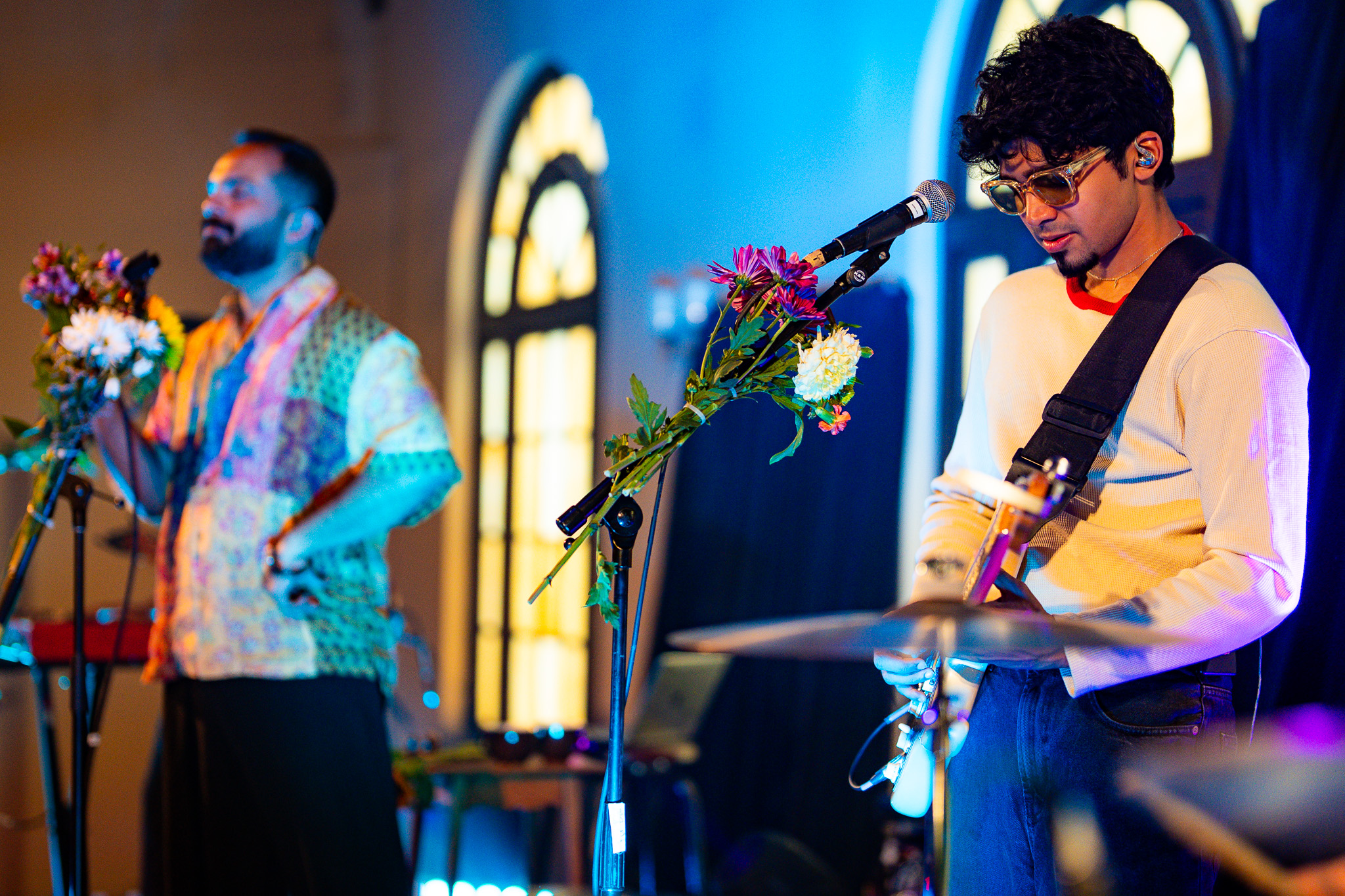 Two members of When Chai Met Toast perform against Fremont Abbey's glowing windows