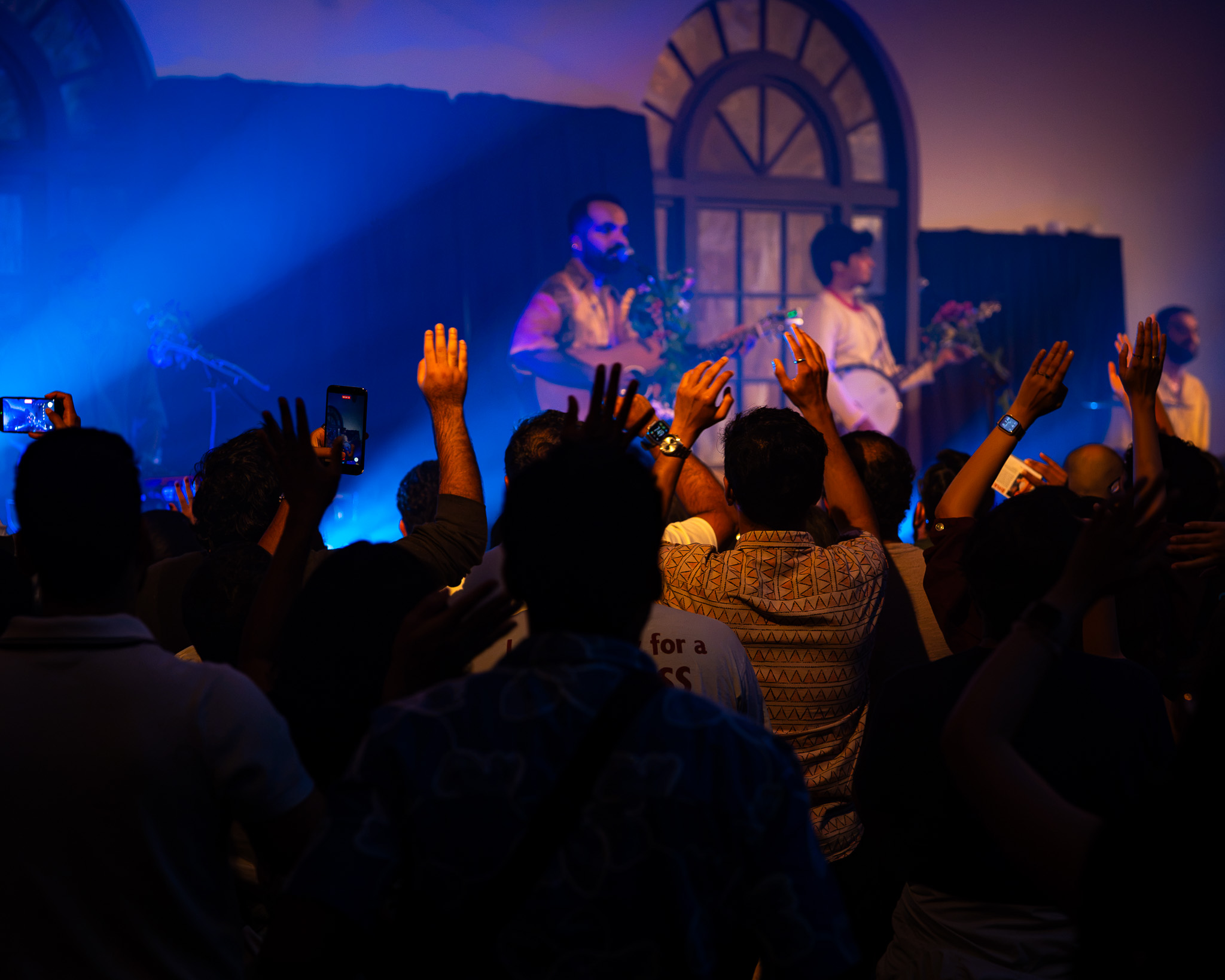 The Fremont Abbey crowd raises their hands toward When Chai Met Toast